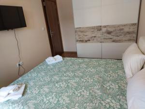 um quarto com uma cama com uma colcha verde e branca em До морето em Burgas