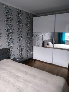 een slaapkamer met een bed en een spiegel aan de muur bij Apartament Mazurski nad Węgorapą in Węgorzewo