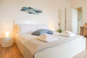 1 dormitorio con 1 cama con toallas en Suite LightHouse, en Cagliari