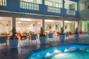 a restaurant with a pool and tables and chairs at Princessa Vera Hotel Apartments in Paphos