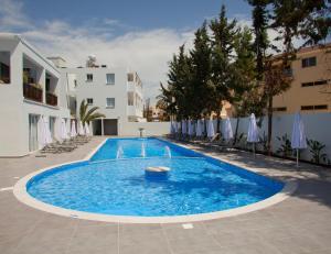 a large blue swimming pool next to a building at Princessa Vera Hotel Apartments in Paphos