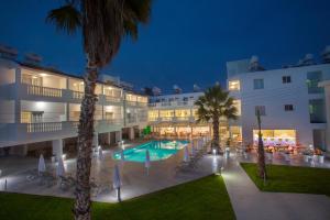 a hotel with a swimming pool at night at Princessa Vera Hotel Apartments in Paphos