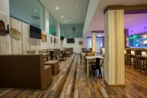 a restaurant with tables and chairs and a bar at Princessa Vera Hotel Apartments in Paphos