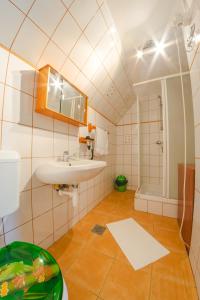 een badkamer met een wastafel, een spiegel en een bad bij Linett Apartman in Hajdúszoboszló