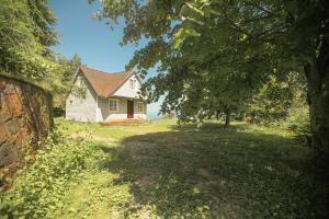 uma casa branca com uma árvore em frente em Эко-дом в горах em Ch'aisubani