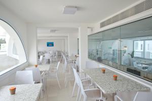 a restaurant with white tables and white chairs at Princessa Vera Hotel Apartments in Paphos