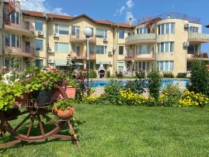a large apartment building with plants in a yard at Apartments in complex Daisy in Kranevo