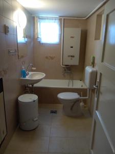 ハイドゥソボスローにあるRáday Apartmanのバスルーム(洗面台、トイレ、バスタブ付)