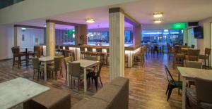 a restaurant with tables and chairs and a bar at Princessa Vera Hotel Apartments in Paphos