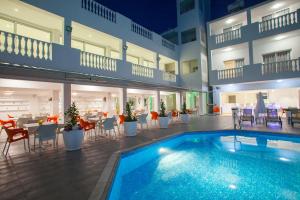 a hotel with a swimming pool and tables and chairs at Princessa Vera Hotel Apartments in Paphos