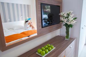 a bedroom with a mirror and a table with a bowl of fruit at Princessa Vera Hotel Apartments in Paphos