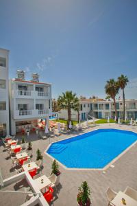 a resort with a swimming pool and chairs and a building at Princessa Vera Hotel Apartments in Paphos