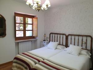 1 dormitorio con 2 camas y ventana en La Pumarada de Limés I en Cangas del Narcea