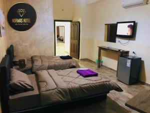 a room with two beds and a television in it at Normas Hotel in Amman