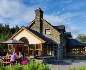 mensen aan tafels buiten een gebouw bij Álaind Lodges, Sneem in Sneem