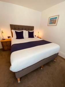 a bedroom with a large bed with blue and white pillows at Self Contained Guest Suite 1 - Weymouth in Weymouth