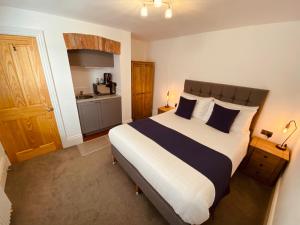 a bedroom with a large bed and a kitchen at Self Contained Guest Suite 1 - Weymouth in Weymouth