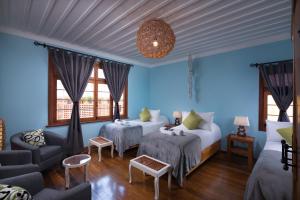 Habitación azul con 2 camas y sofá en Esencia Hotel Boutique, en Viña del Mar