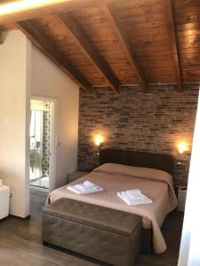 ein Schlafzimmer mit einem Bett und einer Ziegelwand in der Unterkunft Pozzillo San Rocco in Arnesano