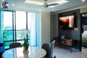 a dining room with a table and a tv at JF Apartments in Tegucigalpa
