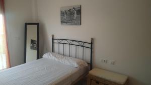 een slaapkamer met een bed en een spiegel aan de muur bij ATICO DUPLEX UMA in Benicarló +30 foto's