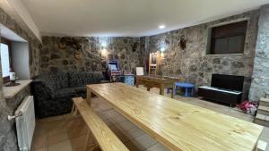 sala de estar con mesa y sofá en Casa Rural Juanín - Alojamiento Turístico Gold, en Fresnedoso de Ibor