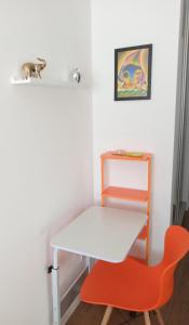a white table and a orange chair in a room at Estudio Monoambiente in Cochabamba