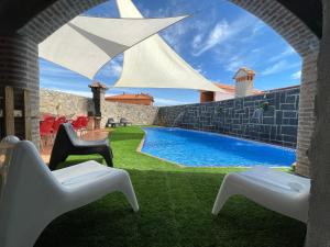 un patio con sillas y una piscina en Casa Rural Juanín - Alojamiento Turístico Gold en Fresnedoso de Ibor