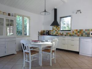 cocina con mesa blanca y sillas en la petite maison en Espiet