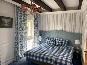 a bedroom with a blue and white bed and a window at Rowy Luxury in Rowy