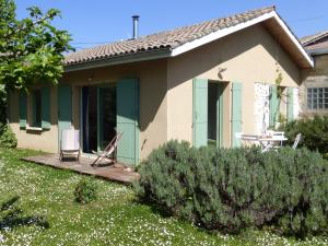 ein Haus mit einem Tisch und einem Stuhl auf einer Veranda in der Unterkunft la petite maison in Espiet