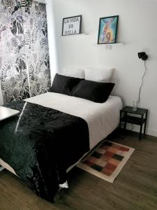 um quarto com uma cama com um cobertor preto e branco em Estudio Monoambiente em Cochabamba