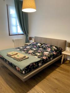 Un dormitorio con una cama con una manta floral. en AFFITTACAMERE DA ANDRE E MARY, en Venzone