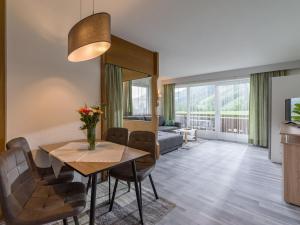 una sala da pranzo con tavolo e sedie e un soggiorno di Appartementhaus Montana KG a Walchsee