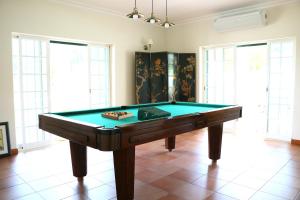 a pool table in the middle of a room with windows at Quinta da Chapeleira em Azeitão in Azeitao