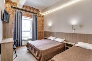 a hotel room with two beds and a window at Nabokov Loft-Hotel in Rostov on Don