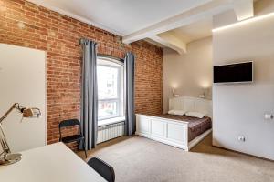a bedroom with a bed and a brick wall at Nabokov Loft-Hotel in Rostov on Don