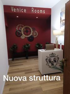 una habitación con una pared roja con un letrero que lee la estructura mulova en Venice Rooms, en Mestre