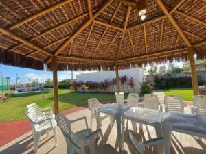 ein Tisch und Stühle unter einem großen hölzernen Sonnenschirm in der Unterkunft Porto de Galinhas, Flat em Muro Alto Condomínio Clube in Ipojuca