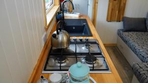 a tiny kitchen with a stove and a sink at Unique Upcycled Straw Trailer Westcote in Hawick