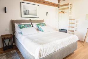1 dormitorio con 1 cama con sábanas y almohadas blancas en La Caliera di Mati, en Roncade