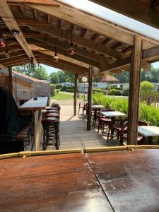 un patio al aire libre con mesas, sillas y mesa de comedor en Château Gaillard baie de Somme, en Forest-Montiers