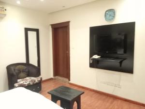 Zimmer mit einem TV, einem Stuhl und einem Bett in der Unterkunft Ebreeze Al Hijaz - Previously Amarena in Dschidda