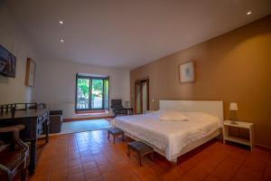 a bedroom with a large bed and a piano at Convento San Payo in Vila Nova de Cerveira
