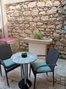 a patio with two chairs and a table and a fountain at Rooms Zela 1 in Korčula