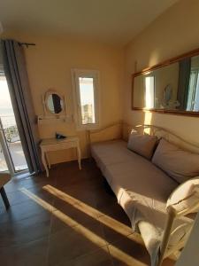 niewielka sypialnia z łóżkiem i oknem w obiekcie Sun And Stone w mieście Athanion