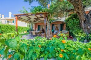 un jardín con pérgola y algunas flores en Wave and Sea Holiday Home en Barbati