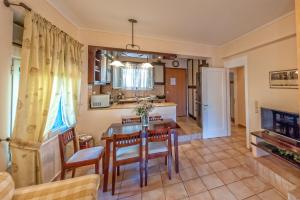 a kitchen and dining room with a table and chairs at Wave and Sea Holiday Home in Barbati