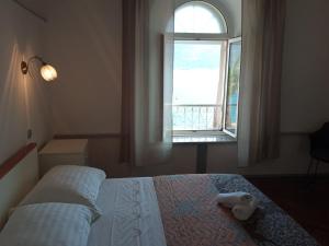a bedroom with a bed with a window at Rooms Zela 1 in Korčula