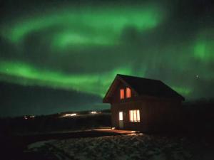 a cabin under the northern lights at night at Greystone summerhouse in Egilsstaðir